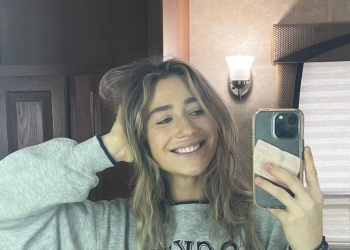 Kamilla Kowal taking a mirror picture wearing a grey sweatshirt.