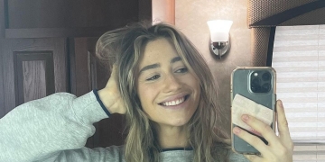 Kamilla Kowal taking a mirror picture wearing a grey sweatshirt.